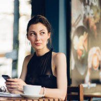 Attractive girl talking on the phone in the cafe